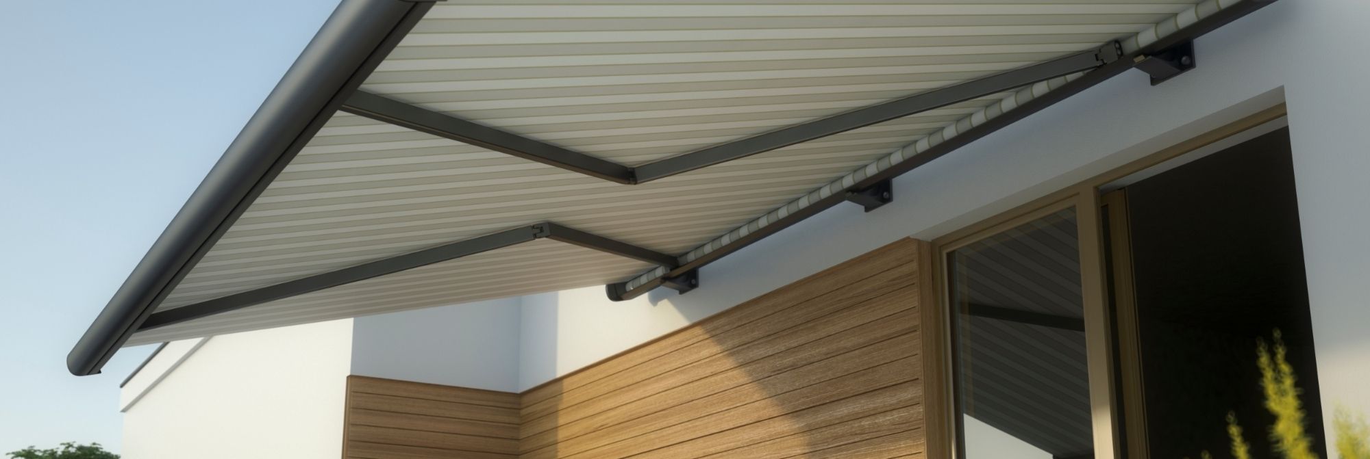 Terrasse mit ausfahrbarer Markise über Sitzbereich an Haus mit Holzverkleidung